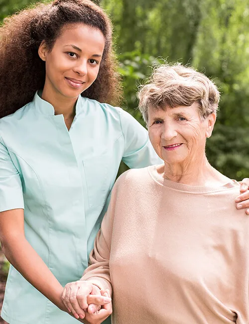 A carer and client walking together outdoors